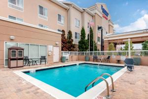 una piscina frente a un hotel con mesas y sillas en Fairfield Inn & Suites Columbus en Columbus