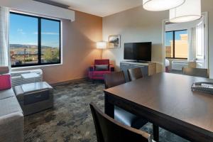 a hotel room with a table and chairs and a living room at TownePlace by Marriott Suites Gallup in Gallup