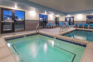 a pool in a hotel room with chairs and tables at TownePlace by Marriott Suites Gallup in Gallup