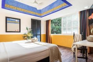 a bedroom with a bed and a table and windows at Soy Local CDMX in Mexico City