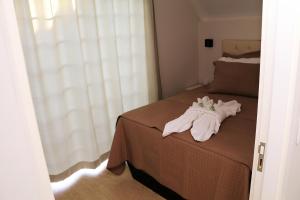 um quarto com uma cama com toalhas em POUSADA GERMÂNICA em Marcelino Ramos