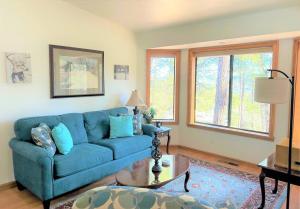 a living room with a blue couch and a table at Mountain Cabin Retreat in the Pines in Prescott
