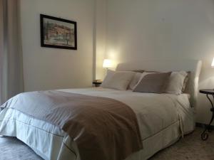 ナポリにあるVomero District Apartmentのベッドルーム(白い大型ベッド、ランプ2つ付)