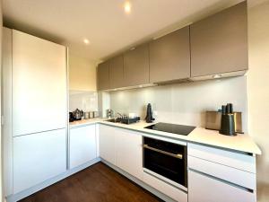 a kitchen with white cabinets and stainless steel appliances at Super Trendy Apartment - Free Parking & Fast WiFi - 1 Minute walk to Poole Quay - Great Location - Free Parking - Fast WiFi - Smart TV - Newly decorated - sleeps up to 2! Close to Poole & Bournemouth & Sandbanks in Poole +9 photos