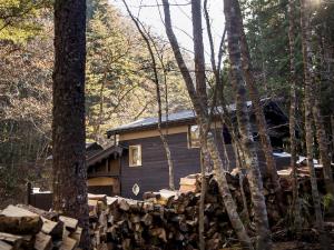 eine Hütte im Wald neben einem Haufen Holz in der Unterkunft Sumiya Rakusuitei - Vacation STAY 17241v in Takayama
