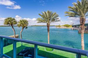 a view of the water from a balcony with palm trees at Beach Haus Bal Harbour in Miami Beach