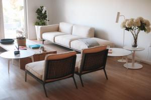 a living room with a couch and a table and chairs at Beach Haus Bal Harbour in Miami Beach