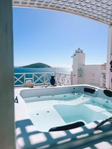 a hot tub on a patio with a view of the ocean at Casa Mar da Grécia in Arraial do Cabo
