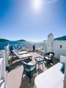 a balcony with chairs and tables and a view of the water at Casa Mar da Grécia in Arraial do Cabo