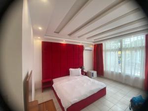 a bedroom with a large bed with a red headboard at Hôtel rotana in Brazzaville