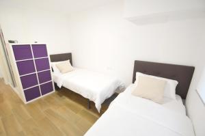 two beds in a room with white and purple at Fuengirola, Primera linea de playa in Fuengirola