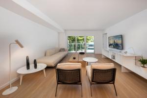 a living room with a couch and a table and chairs at Beach Haus Bal Harbour in Miami Beach