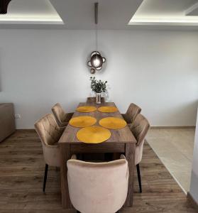 a dining room with a wooden table and chairs at Sunshine Homes Zamárdi in Zamárdi
