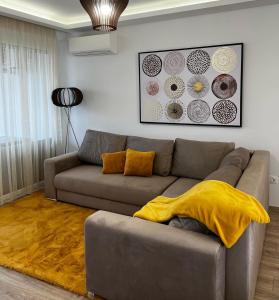 sala de estar con sofá y manta amarilla en Sunshine Homes Zamárdi en Zamárdi
