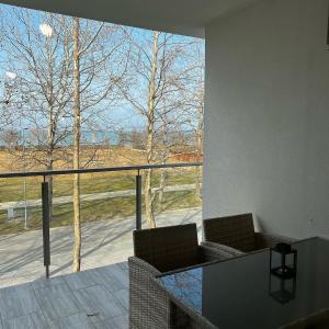 balcón con 2 sillas y ventana grande en Sunshine Homes Zamárdi, en Zamárdi