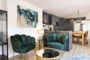 sala de estar con 2 sillas verdes y mesa en The Cove, en Seaview
