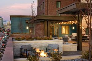 un patio avec des chaises et un foyer extérieur en face d'un bâtiment dans l'établissement Residence Inn by Marriott Boise Downtown City Center, à Boise