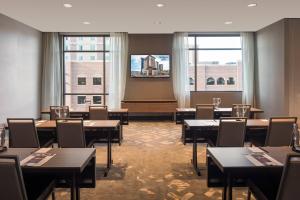 a dining room with tables and chairs and windows at Residence Inn by Marriott Boise Downtown City Center in Boise
