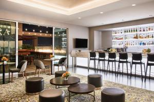 a bar in a hotel lobby with chairs and tables at AC Hotel by Marriott Los Angeles South Bay in Los Angeles