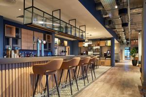 a bar with a row of stools in a restaurant at Residence Inn by Marriott Slough in Slough