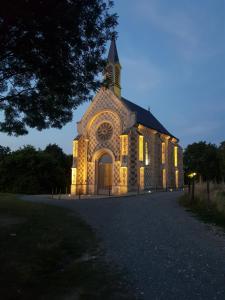 een kerk met zijn lichten aan 's nachts bij Cœurs en Bay - Maison romantique avec parking et terrasse in Saint-Valery-sur-Somme