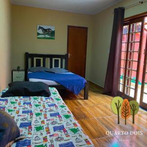 a bedroom with two beds and a wooden floor at Casa Sole & Mare - Praias e Cachoeiras in Paraty