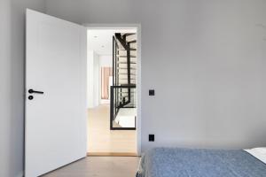 a white bedroom with a bed and a mirror at Stylish and spacious family home in Stockholm