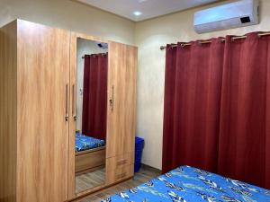 Schlafzimmer mit einem Holzschrank und einem Spiegel in der Unterkunft Superbe mini-villa tout confort! in Ouagadougou