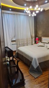 1 dormitorio con 1 cama y 1 silla en LUXURIOUS ACCOMMODATION IN 2BR APARTMENT, IN A SECURED AREA WITH COMFORTABLE DISTANCE TO R/W STATION, AIRPORT AND CITY CENTER., en Tashkent