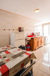 アレシーフェにあるEnsuite Apartment A con Zona de Patioのキッチン(テーブル、白い冷蔵庫付)
