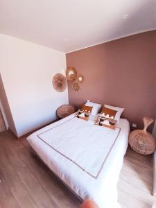 a bedroom with a large bed with baskets on it at P'tit cocon au cœur du Lot in Dégagnac