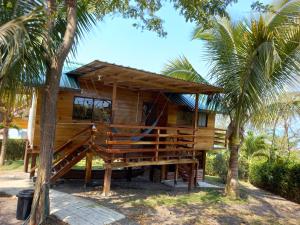 una casa de madera con palmeras delante en L'Oasis Don Juan, en Don Juan