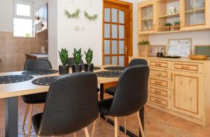 a kitchen with a wooden table and chairs at AKÁCIA APARTMAN in Nyíregyháza