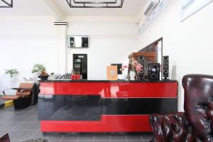 eine Bar mit einer roten und schwarzen Theke in einem Zimmer in der Unterkunft Jaka Homestay in Rembang