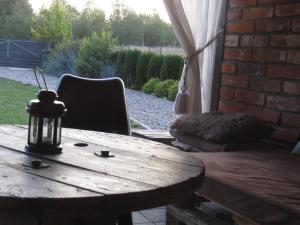 une table en bois, une chaise, une table et un mur en briques dans l'établissement Cudodomek SPA w Mrozach Wielkich koło Ełku, à Ełk