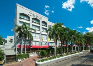 a building with palm trees in front of it at Country International Hotel in Barranquilla