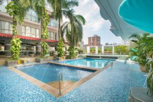 a swimming pool in the middle of a building with palm trees at Country International Hotel in Barranquilla