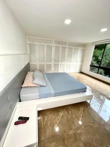 1 dormitorio con cama y ventana grande en Apartamento hermoso en el mejor barrio Medellín, en Medellín