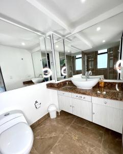 ein Bad mit einem WC, einem Waschbecken und Spiegeln in der Unterkunft Apartamento hermoso en el mejor barrio Medellín in Medellín
