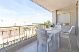 einen weißen Tisch und Stühle auf einem Balkon mit Aussicht in der Unterkunft Complejo Residencial-CAT-8 in Salou