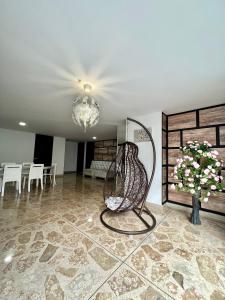 ein Zimmer mit einem Stuhl und einer Vase aus Blumen in der Unterkunft Apartamento hermoso en el mejor barrio Medellín in Medellín