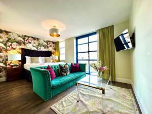 a living room with a green couch and a bed at Chic Modern Apartment Suite - Free Parking & WiFi! - 1 Minute walk to Poole Quay - Great Location - Free Parking - Fast WiFi - Smart TV - Newly decorated - sleeps up to 2! Close to Poole & Bournemouth & Sandbanks in Poole