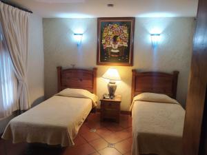 um quarto com duas camas e um candeeiro sobre uma mesa em HOTEL COLONIAL MATAMOROS em Matamoros