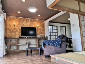 een woonkamer met een tv en een stoel en een tafel bij Ariki Resort Shuzenji - Vacation STAY 52314v in Izu