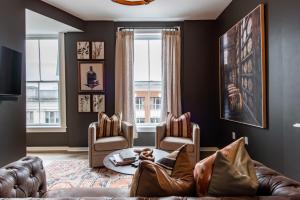 a living room with a couch and two chairs at The Woodford Hotel in Versailles