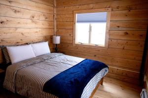 ein Schlafzimmer mit einem Bett in einem Blockhaus in der Unterkunft The Grafton Lodge in Grafton