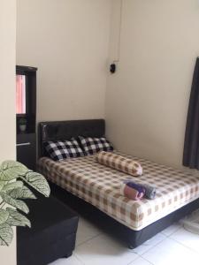 ein Bett mit zwei Kissen auf einem Zimmer in der Unterkunft Jaka Homestay in Rembang