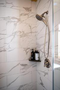 bagno con doccia e pareti in marmo bianco di The Grafton Lodge a Grafton