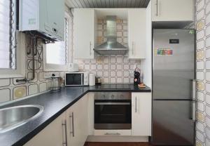 a kitchen with white cabinets and a stainless steel refrigerator at Stay U-nique Apartments Calabria in Barcelona