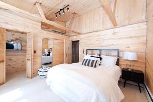 1 dormitorio con 1 cama y pared de madera en 21461 Hwy 140 - Hesperus, en Hesperus